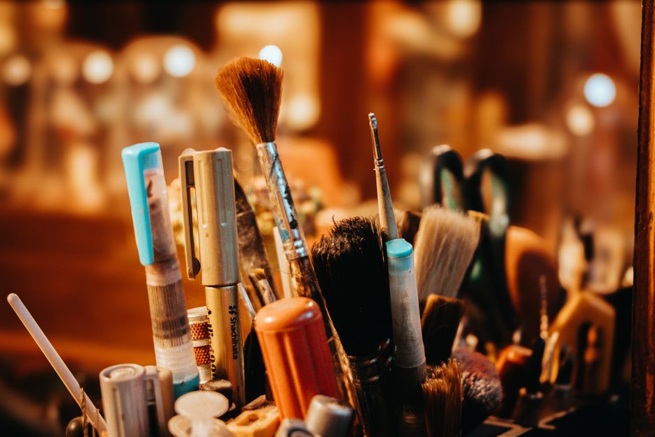 A vibrant assortment of art and makeup brushes in a cozy studio setting.